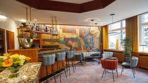 A bar area with a counter, bar stools, and a seating area with chairs and a sofa. - TOP VCH Hotel Wartburg Stuttgart (Stuttgart)