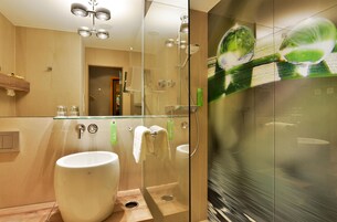A modern bathroom with a glass-enclosed shower, a large sink, and a mirror.