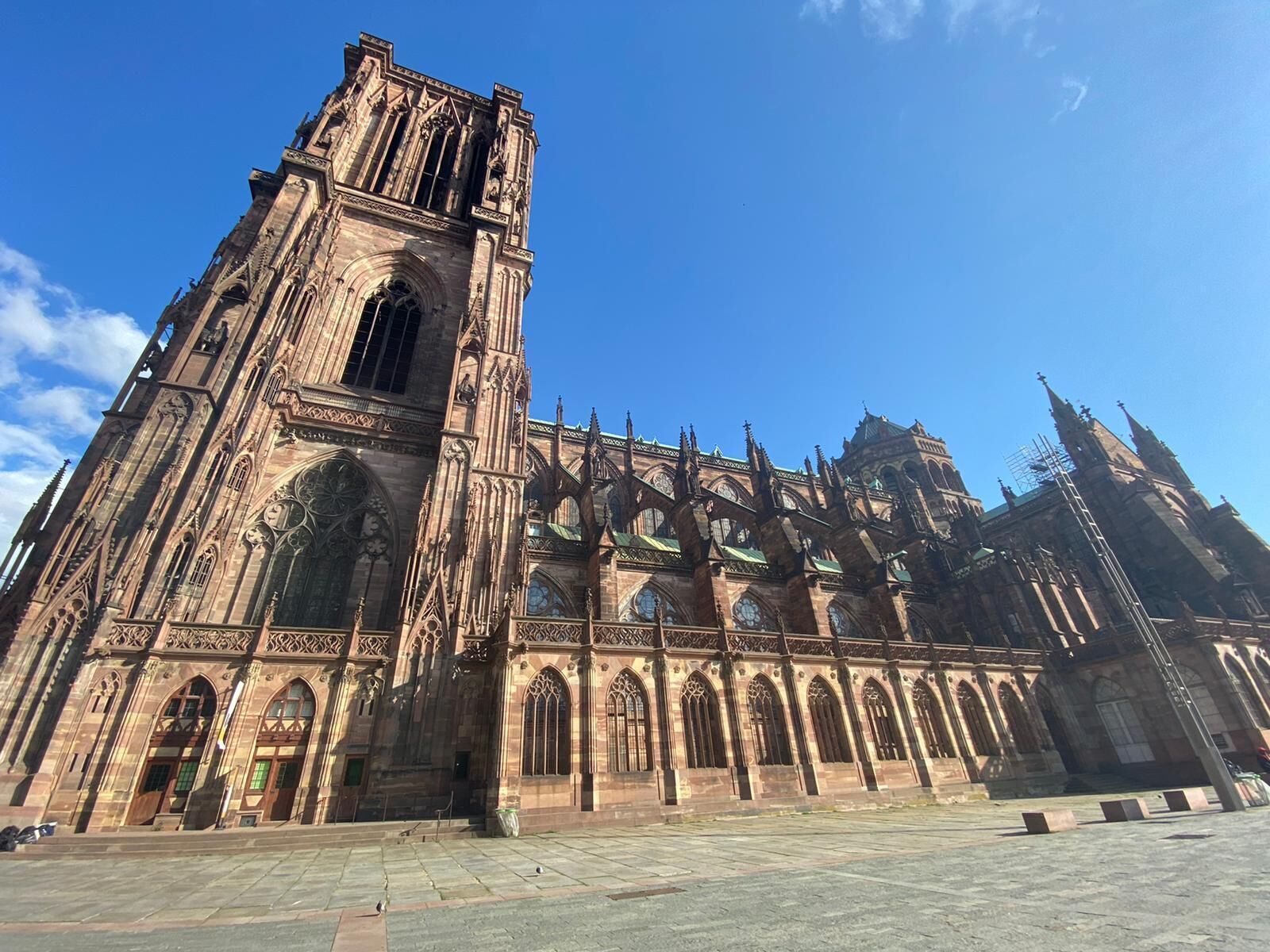Una gran catedral gótica con una alta torre central y múltiples ventanales de arco.