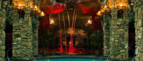 A pool area with stone walls and a waterfall feature.