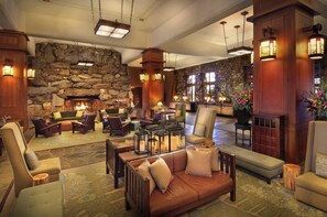A spacious lobby with a stone wall, comfortable seating, and a fireplace.