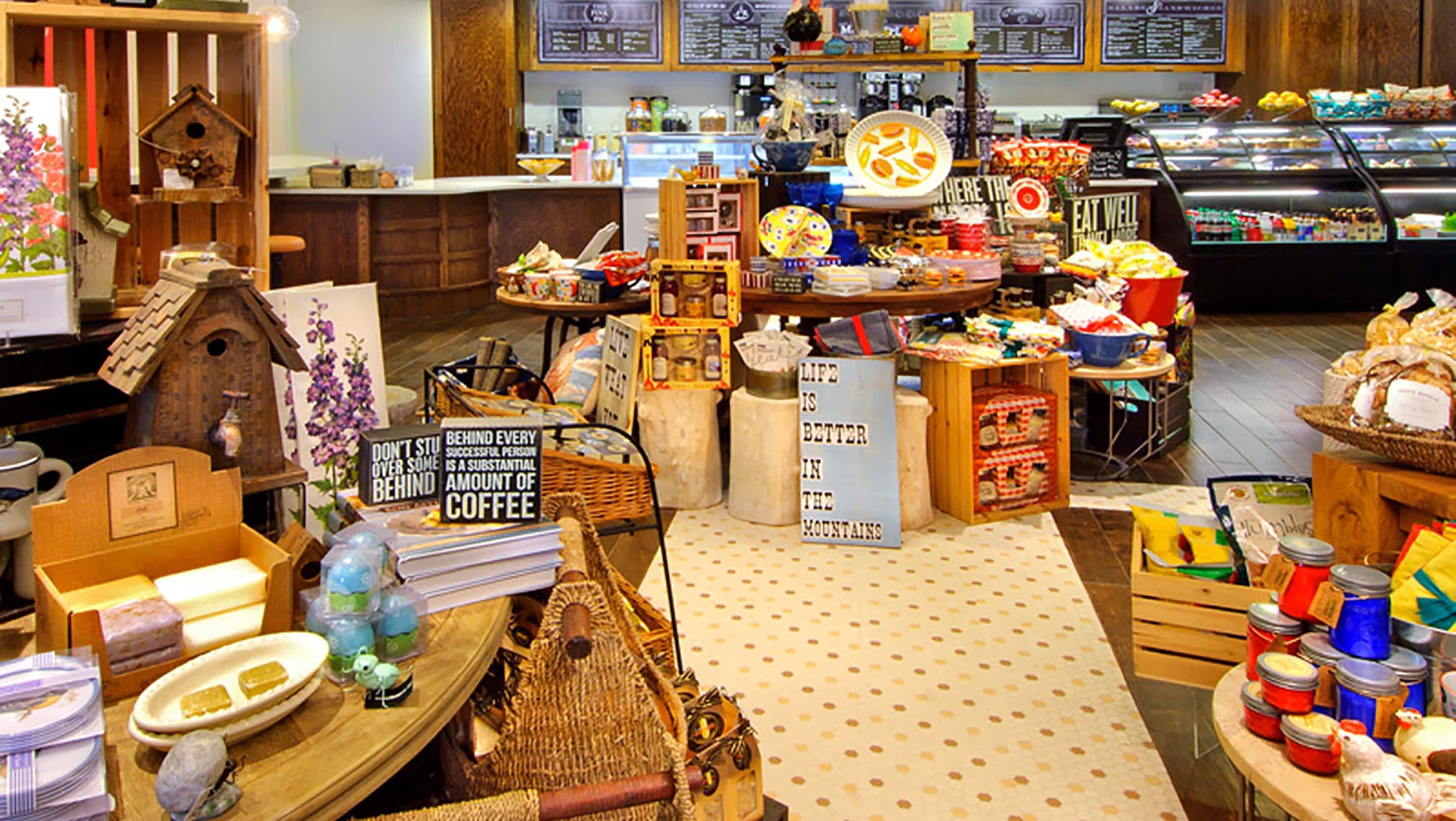 A cozy cafe with wooden decor, a variety of food items, and a coffee station.