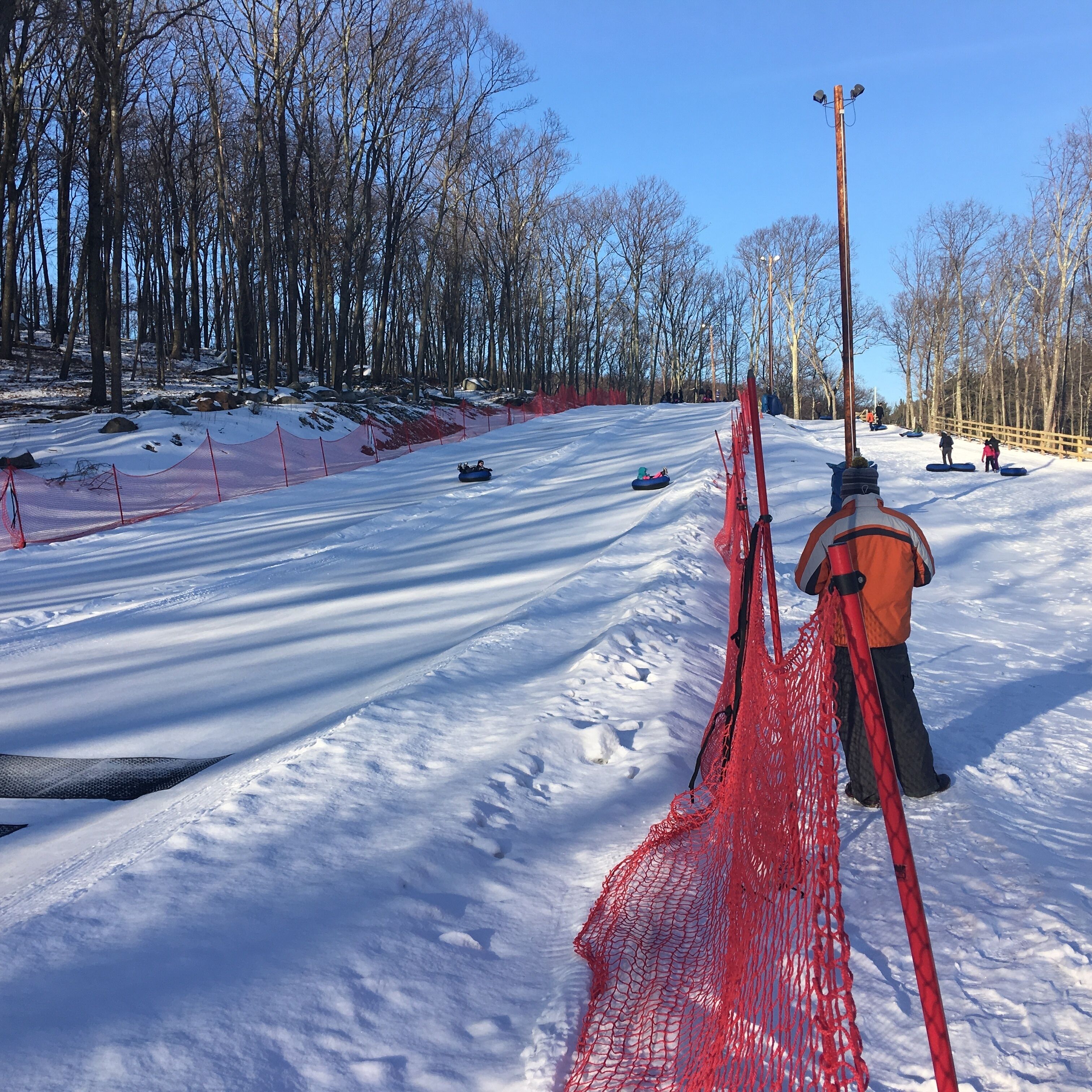A snowy landscape with a red netted area, likely for a winter sport.