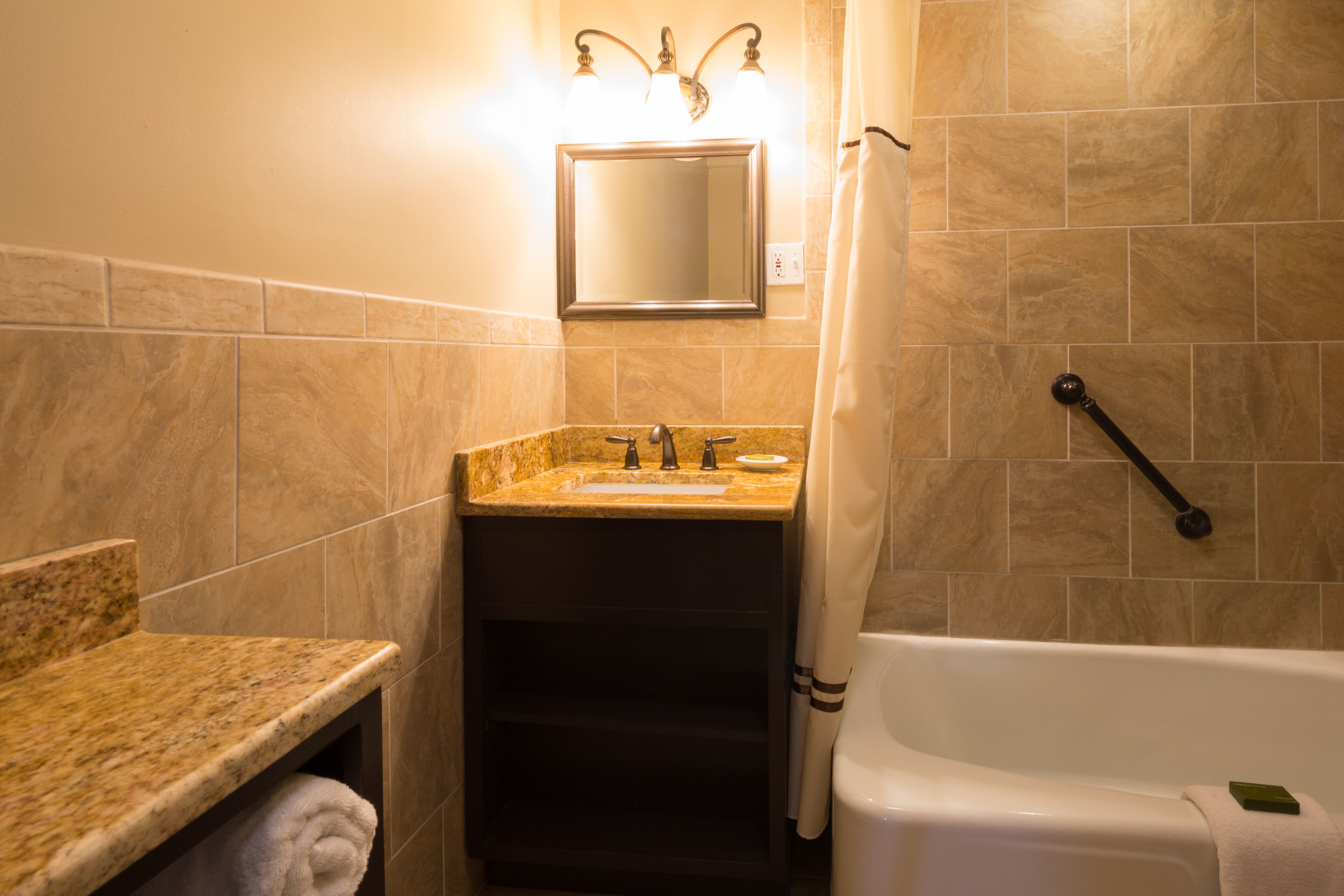 Un baño con lavamanos, espejo y bañera.