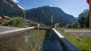 Una fuente de agua con bancos en una zona montañosa.