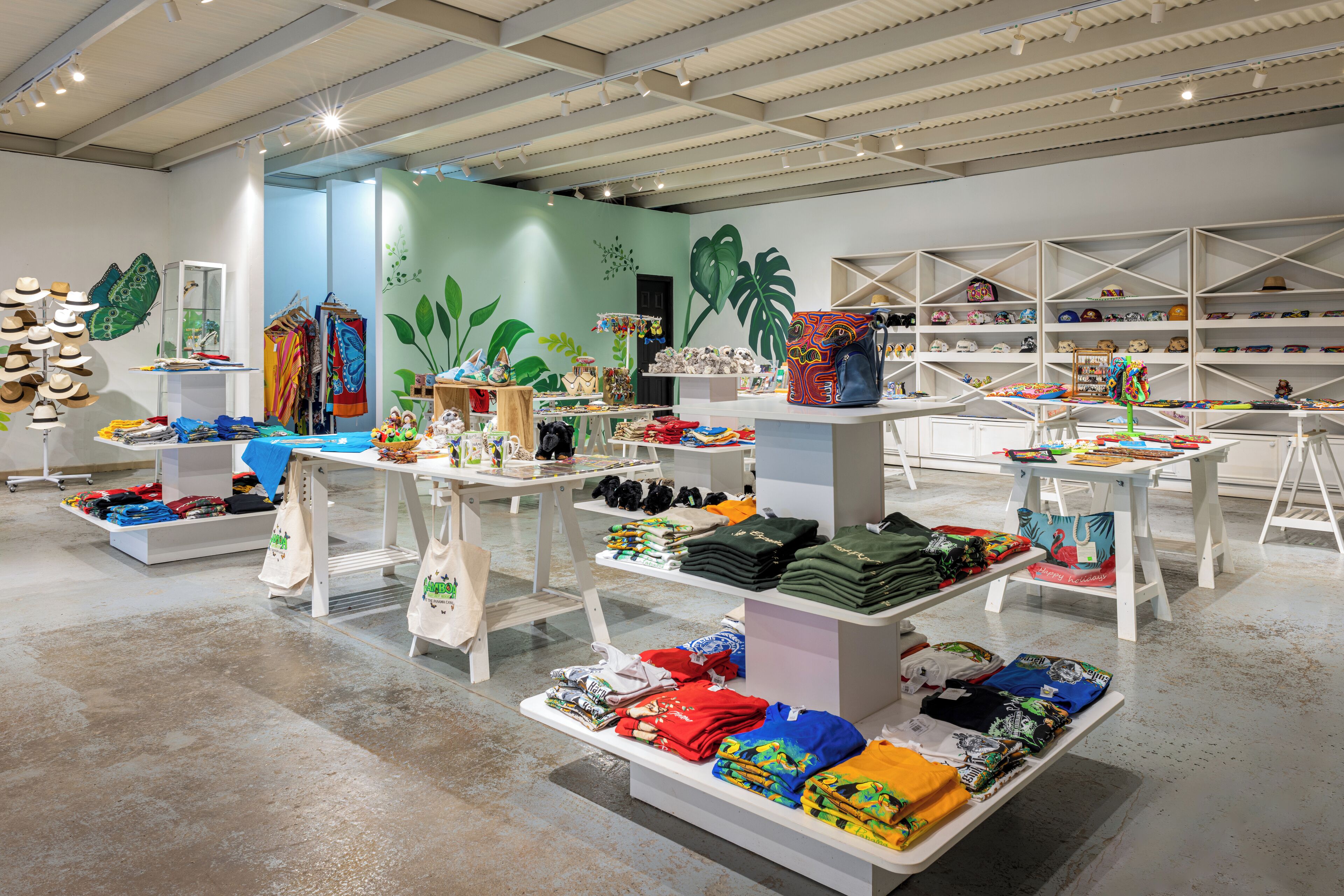 A spacious retail store with multiple display tables and shelves filled with various clothing items and accessories.