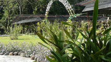A sign for a resort nursery with a garden in the foreground.