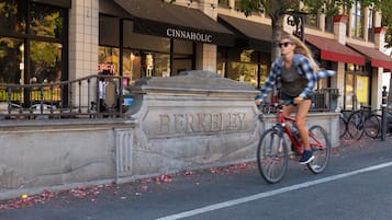 A street scene with a cyclist riding past a building with the name 'BERKELEY' engraved on a stone wall.
