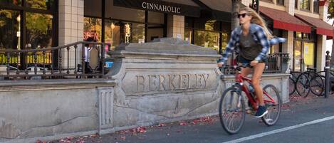 Una calle con un ciclista pasando frente a un edificio cuyo nombre, 'BERKELEY', está grabado en una pared de piedra.