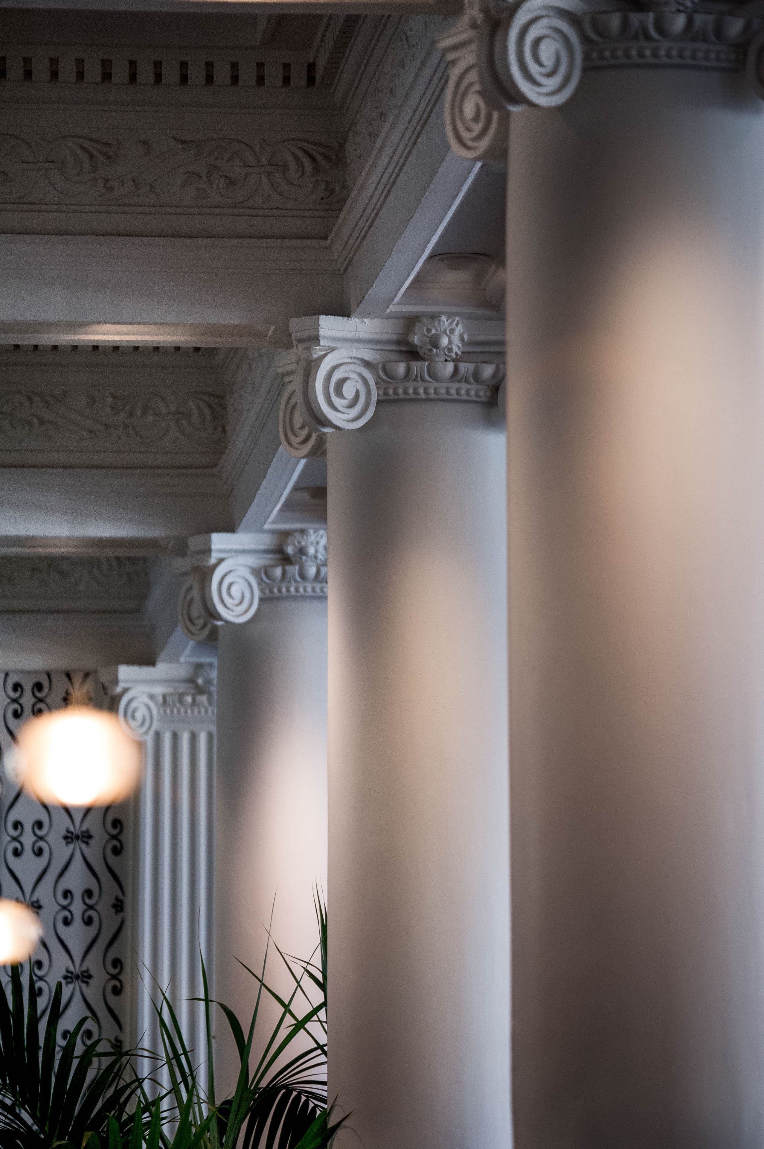 A corridor with ornate columns and a decorative ceiling.