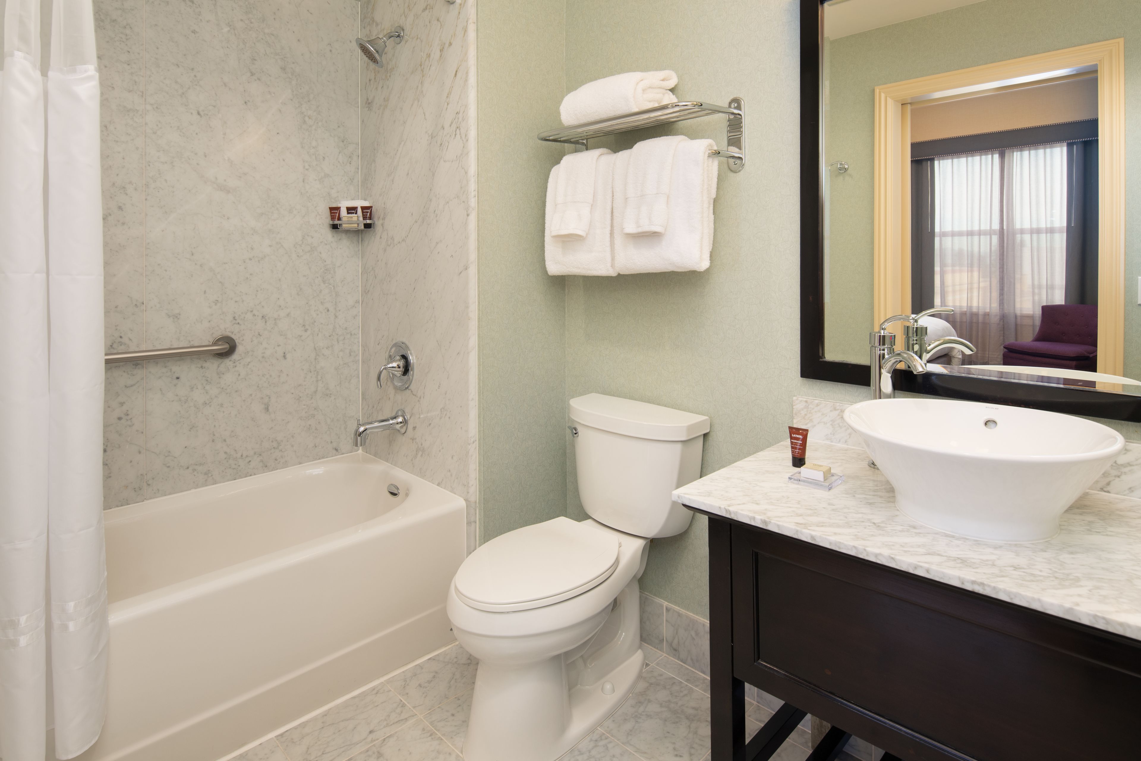 A bathroom with a bathtub, toilet, and sink.