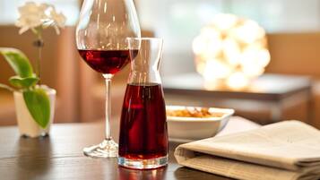A table with a wine glass and a bottle, a small potted plant, and a bowl of food.