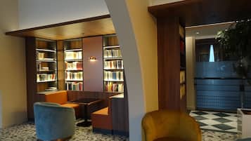 Una biblioteca moderna con estanterías, un rincón de lectura con sillas y un suelo con diseño.