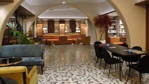 A spacious lobby with a central seating area, a large bookshelf, and a decorative plant. - Aquabella Hôtel & Spa (Aix-en-Provence)
