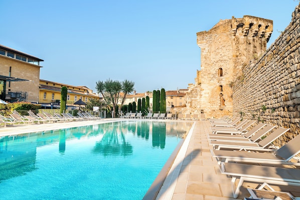 Una piscina al aire libre de temporada, sombrillas