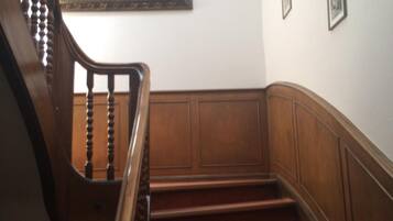 Eine Holzt Treppe mit Handlauf, ein Bild an der Wand und ein kleines gerahmtes Foto.