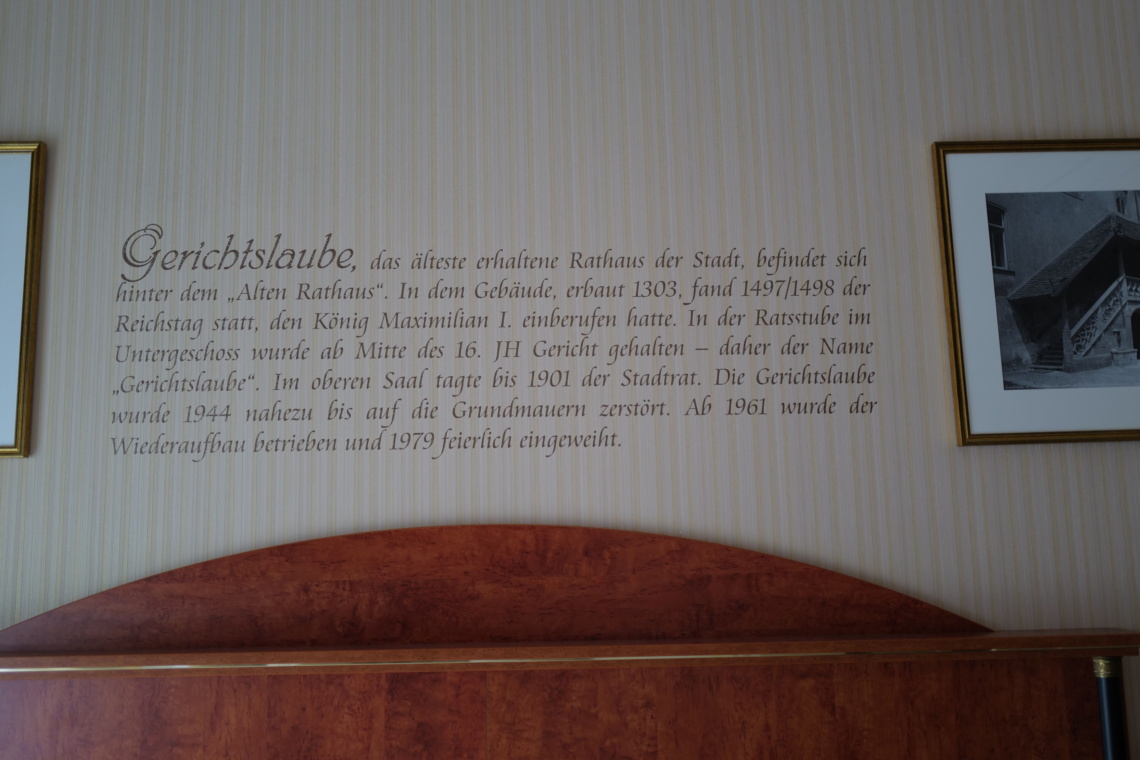 A wall with a plaque detailing the history of a building, including its construction date and restoration.
