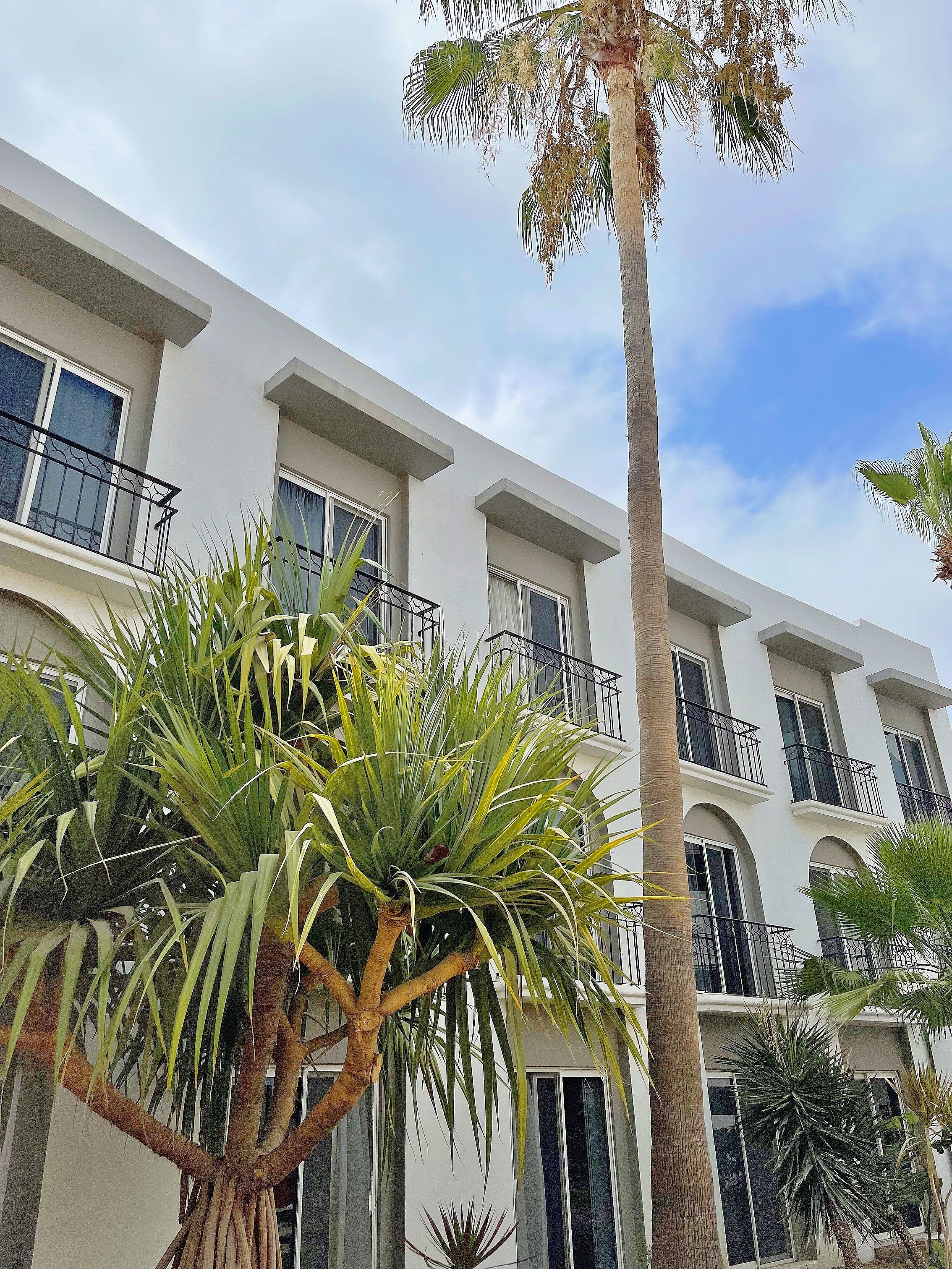 A multi-story building with balconies and large windows.