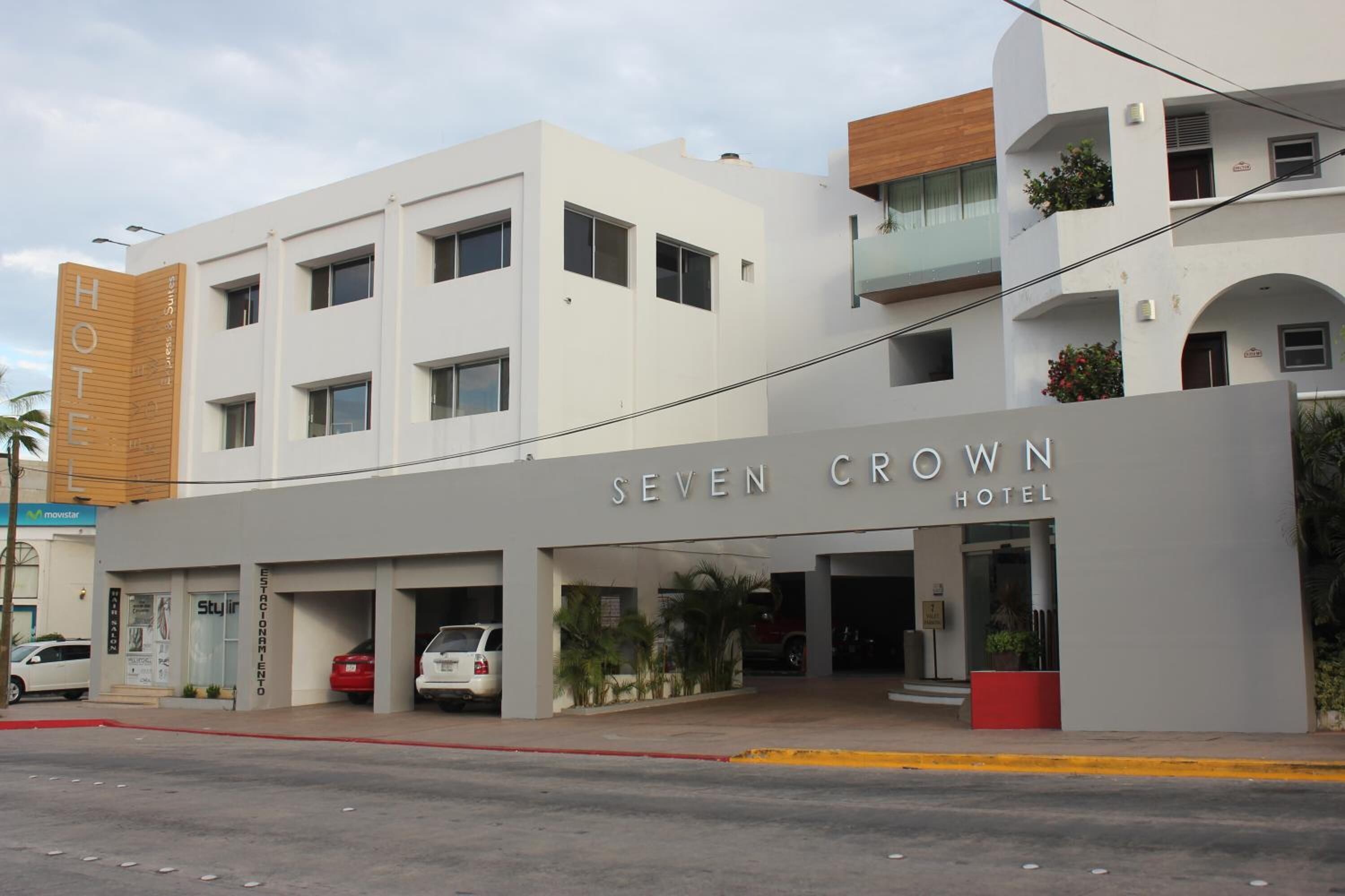 A hotel with a modern facade, a prominent entrance, and a parking area.