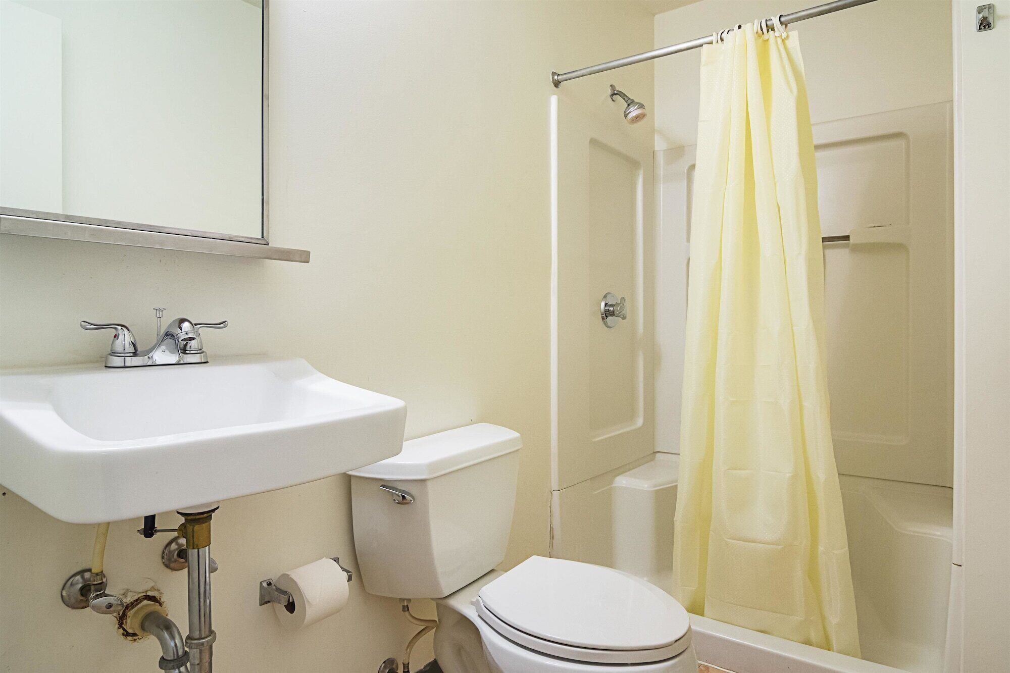 A bathroom with a white sink, toilet, and shower.
