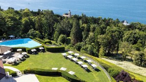 Un complexe hôtelier doté d’une piscine, de chaises longues et offrant une vue sur la mer.