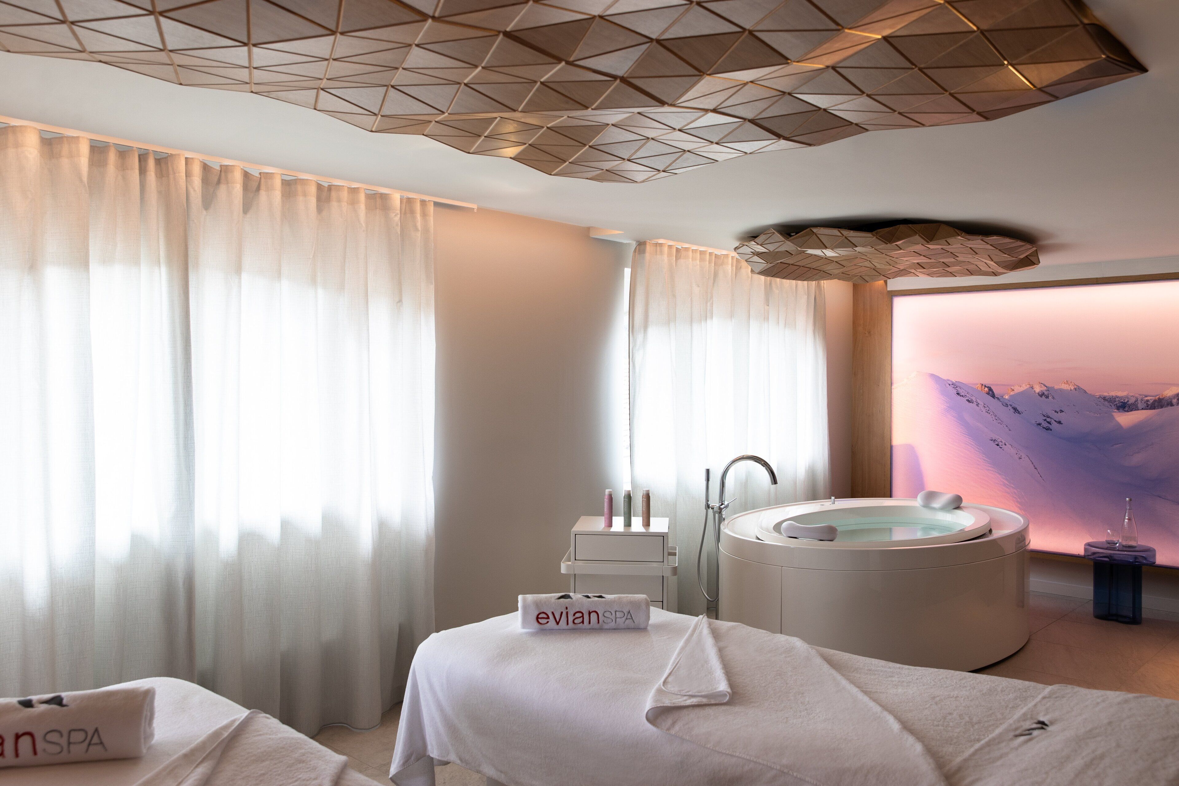 Une salle de spa équipée d’une table de massage, d’une baignoire et d’un fauteuil de massage fixé au mur.