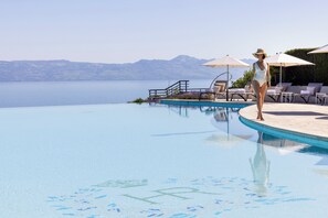 Una piscina al aire libre, sillones reclinables de piscina