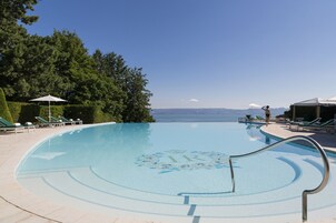 Una piscina al aire libre, sillones reclinables de piscina