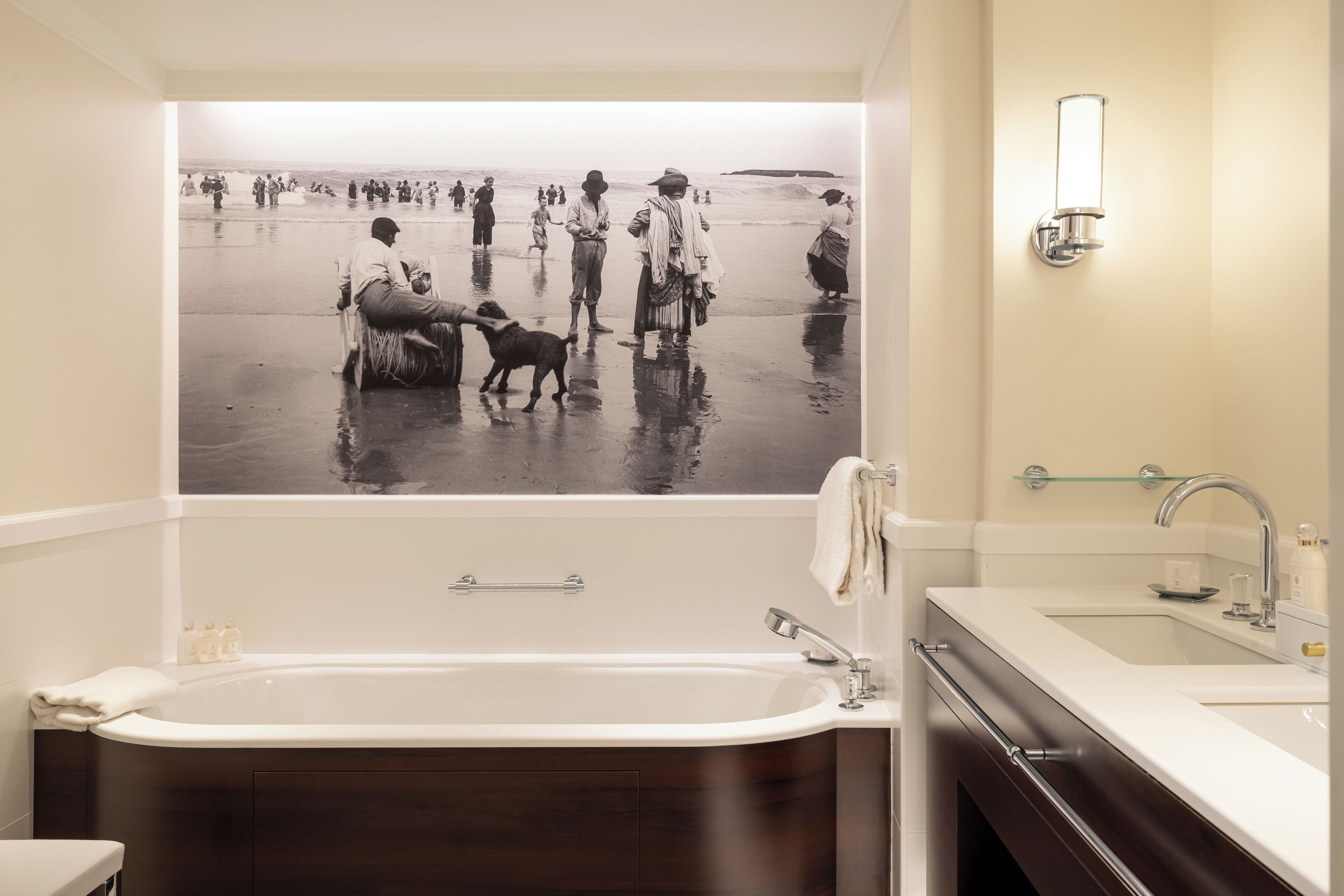 Un baño con una bañera grande, un lavabo y un espejo.