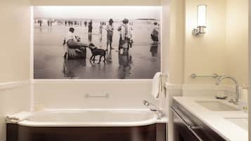 Un baño con una bañera grande, un lavabo y un espejo.