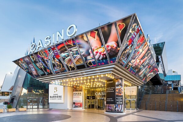 En kasinobyggnad med en framträdande skylt, flera ingångar och en modern arkitektonisk design.