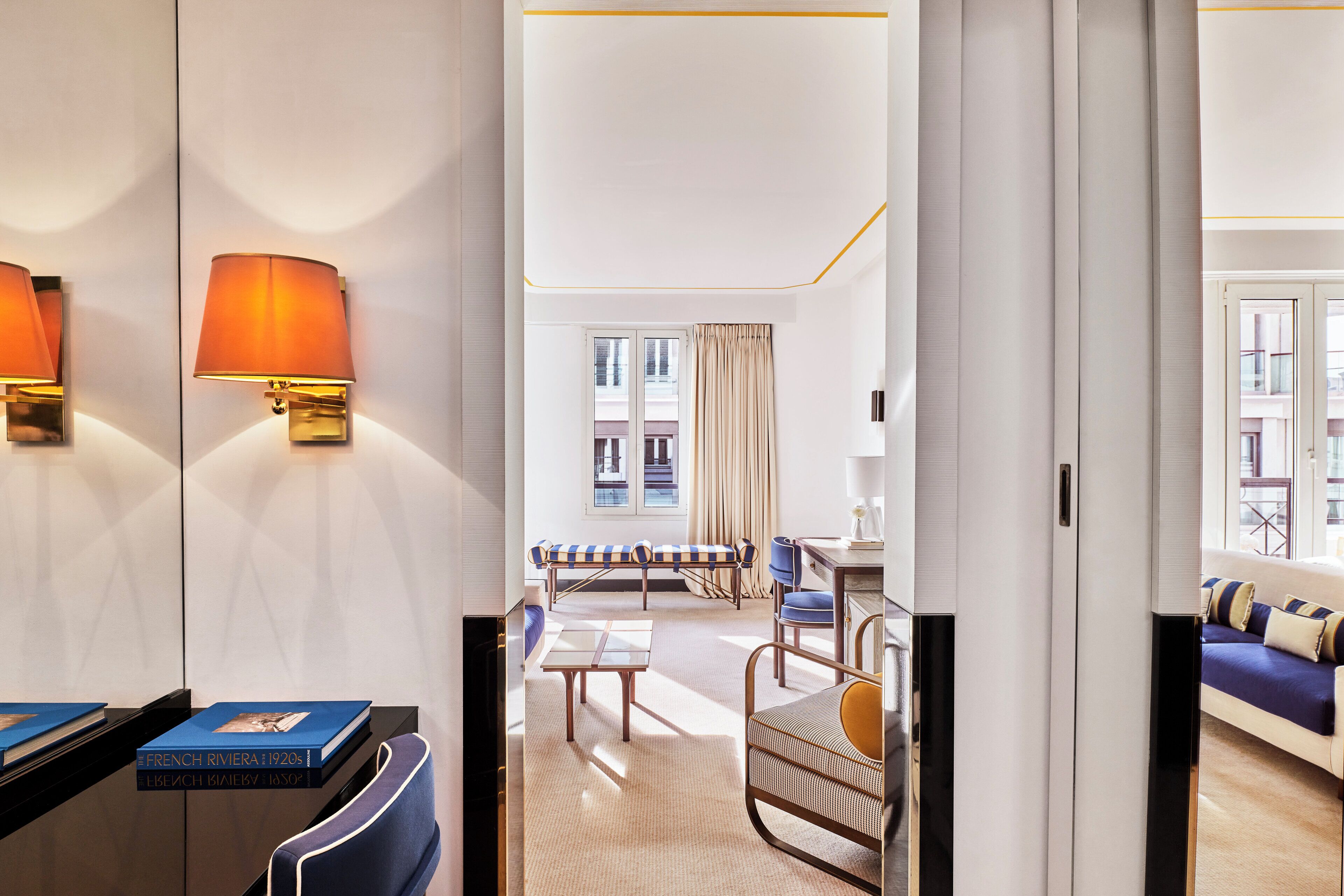 A hotel room with a bed, a sofa, a chair, a table, and a lamp.