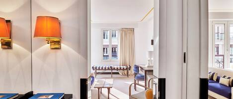 Una habitación de hotel con una cama, un sofá, una silla, una mesa y una lámpara.