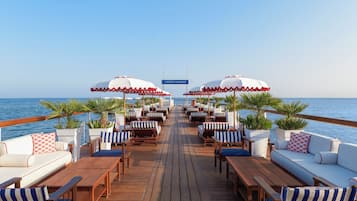 Aan een privéstrand, ligstoelen, parasols, strandlakens
