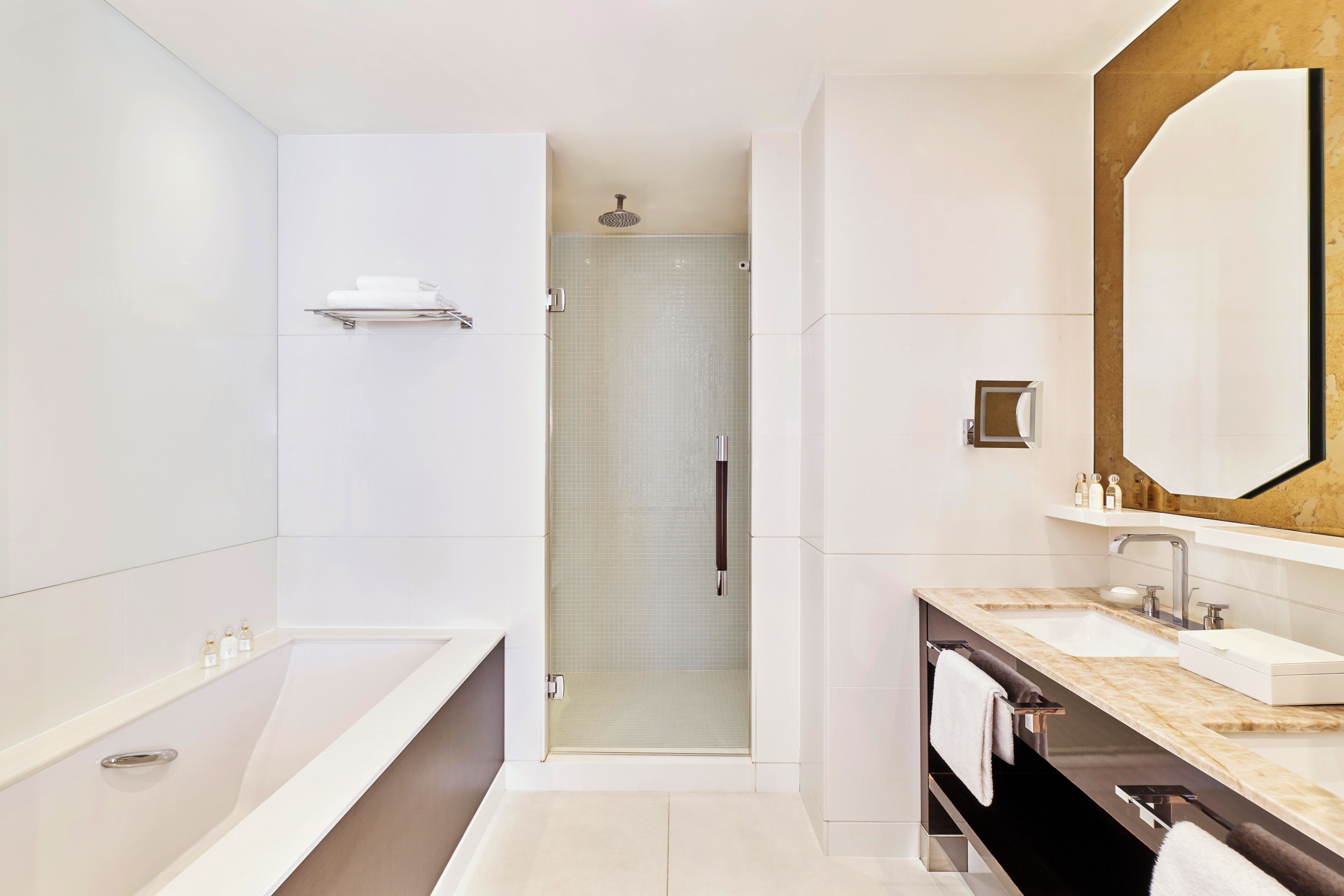 Un baño moderno con una bañera grande, dos lavamanos y una ducha a ras de suelo.
