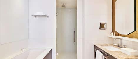Un baño moderno con una bañera grande, dos lavamanos y una ducha a ras de suelo.