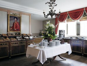 A formal dining room with a table set for service, a large painting on the wall, and a chandelier. - Schlosshotel Kronberg - Hotel Frankfurt (Kronberg)