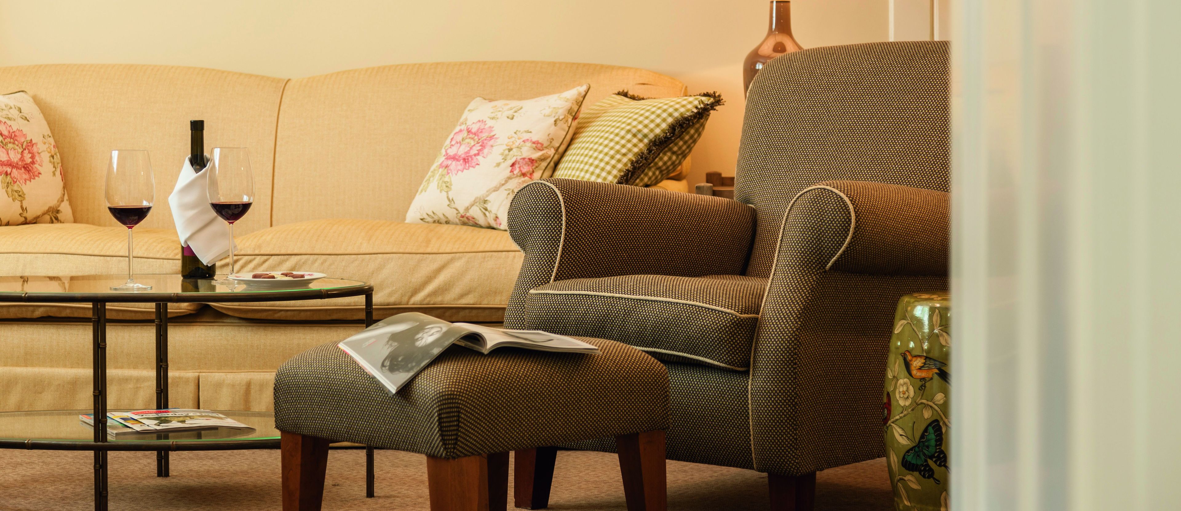 A living room with a sofa, armchair, ottoman, and coffee table.