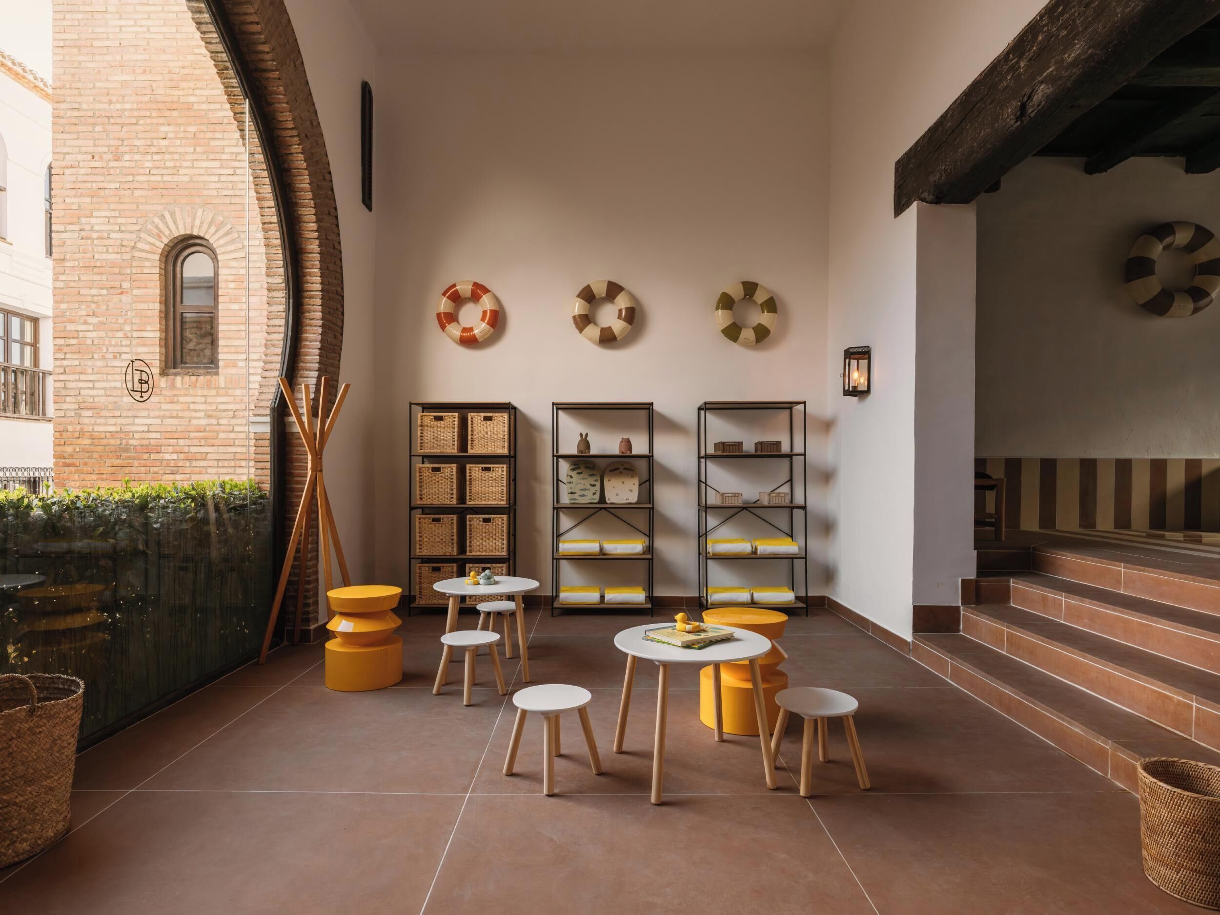 Een gezellig interieur met rieten manden, houten krukken en planken met decoratieve objecten.