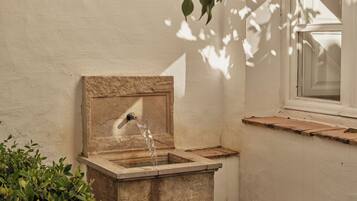 A stone water feature with a window to the right.
