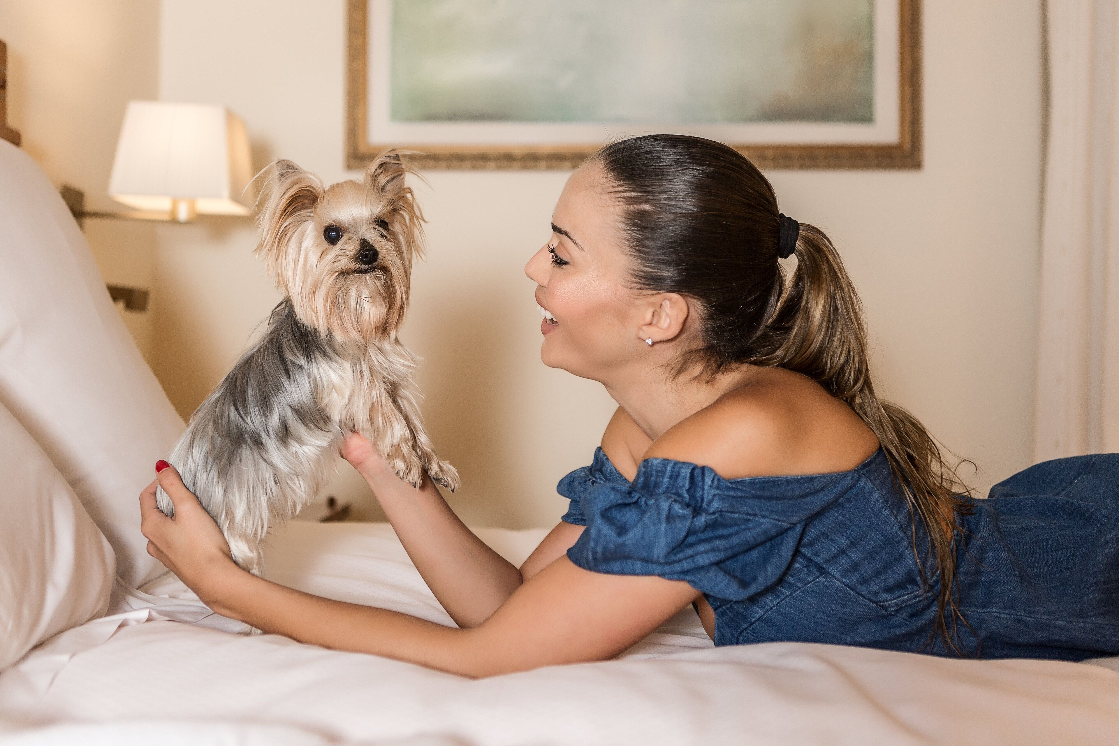 Une personne allongée sur un lit avec un chien.