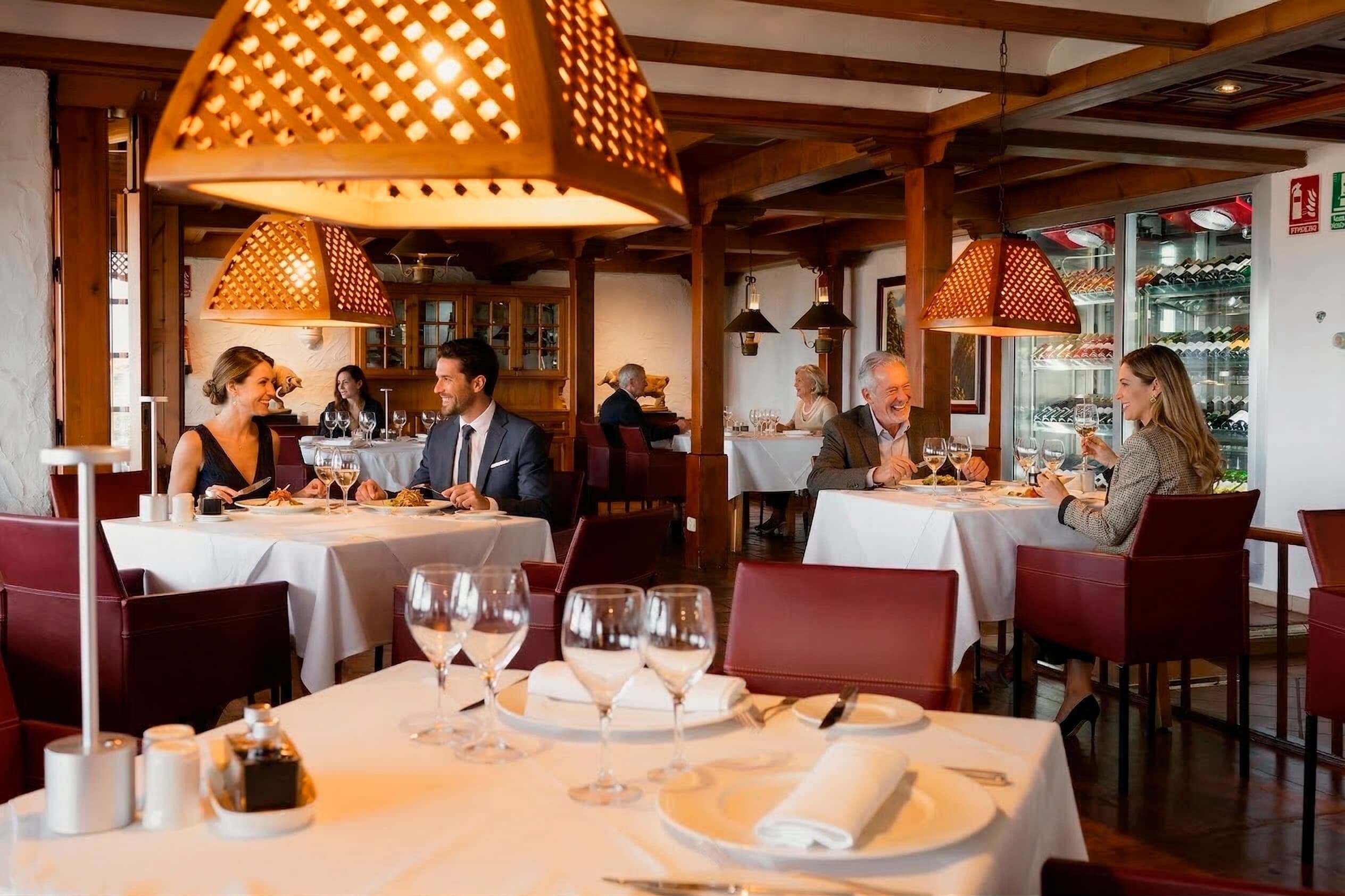 Een restaurant met gedekte tafels, wijnglazen en een fles wijn op tafel.