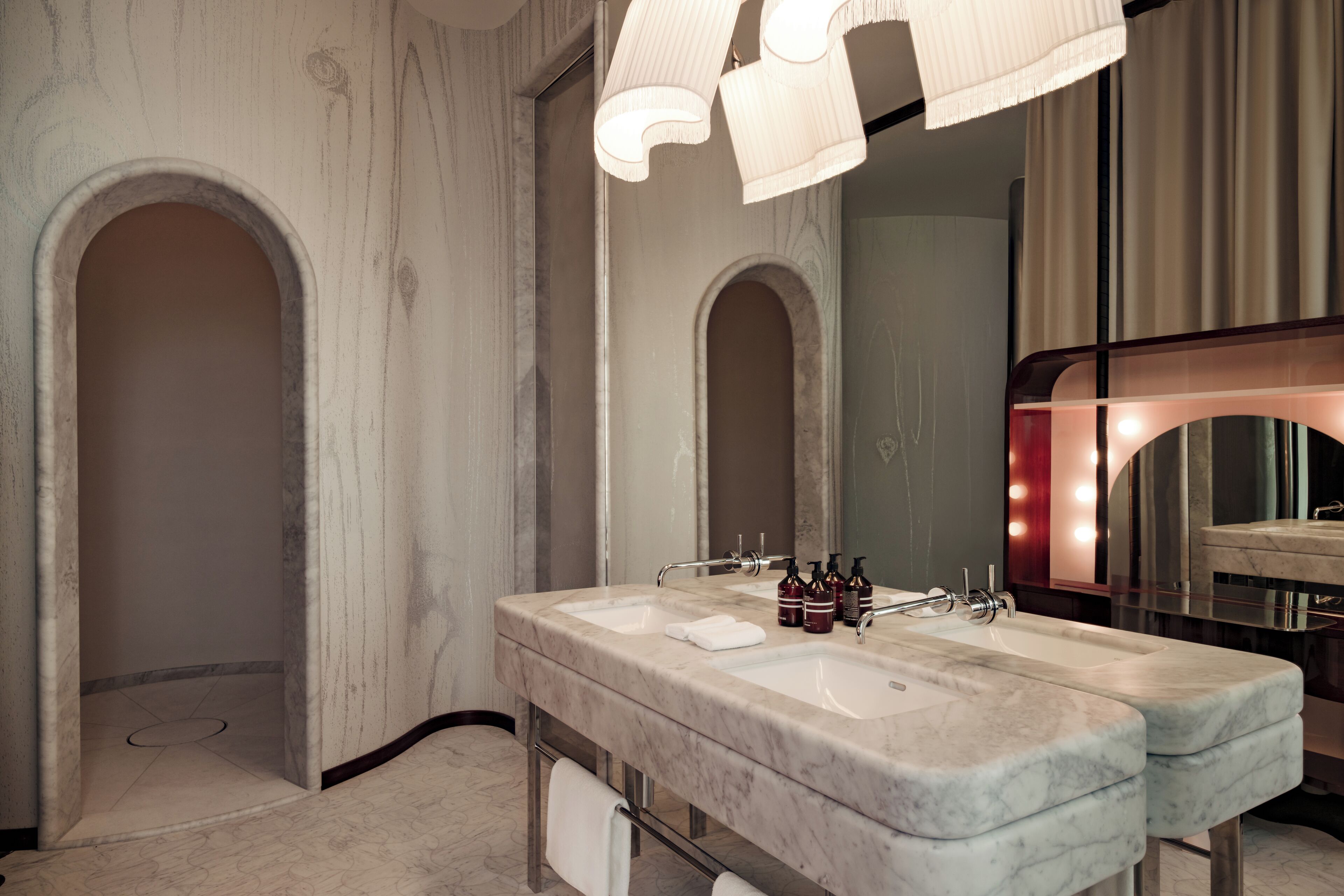 Une salle de bain moderne avec deux vasques, un meuble-lavabo et un grand miroir avec éclairage intégré.