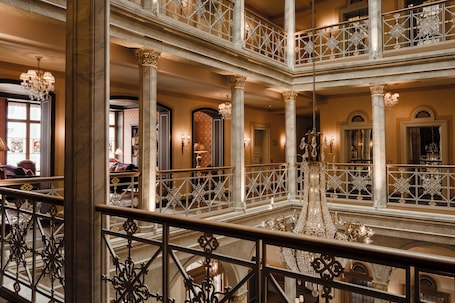 A multi-level atrium with ornate railings and chandeliers.