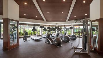 A gym with treadmills, elliptical machines, and free weights.