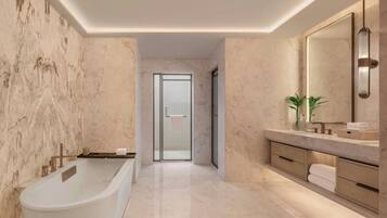 Un baño moderno con una bañera independiente, un espejo grande y paredes de mármol.