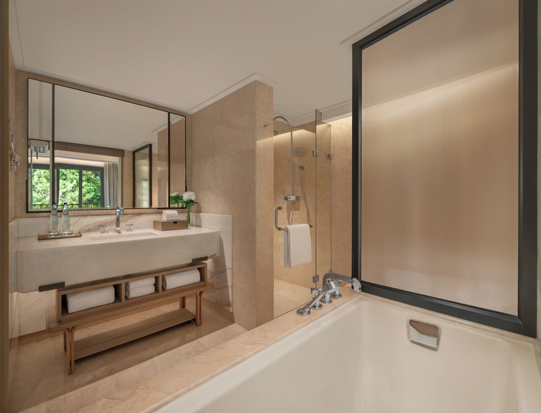 A modern bathroom with a large mirror, a bathtub, and a shower area.