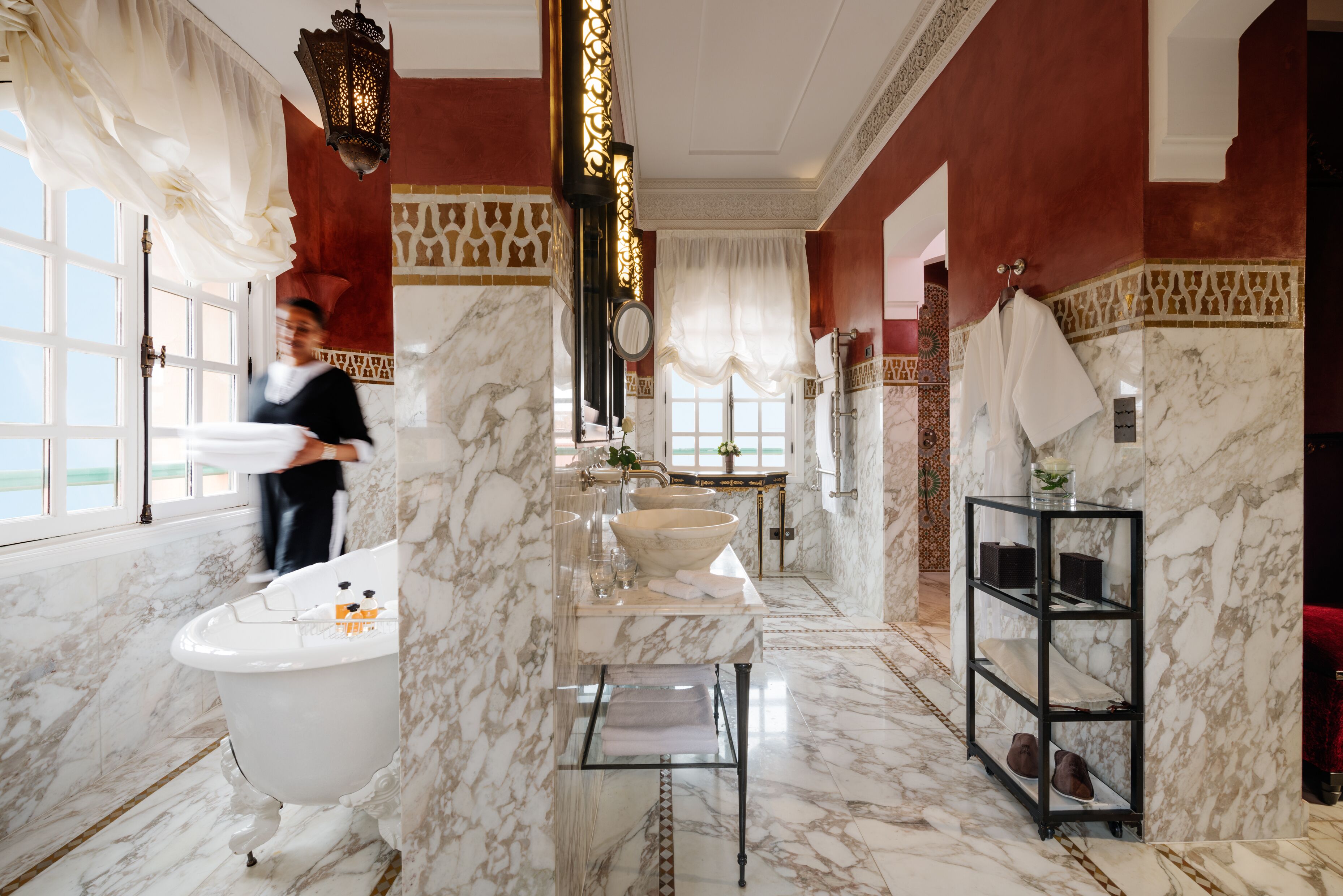 A luxurious bathroom with a freestanding bathtub, a large vanity with a marble countertop, and a marble floor.