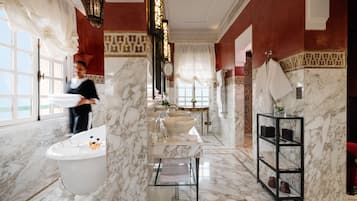 A luxurious bathroom with a freestanding bathtub, a large vanity with a marble countertop, and a marble floor.