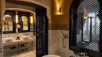 Une salle de bain luxueuse avec une baignoire îlot, deux vasques et un grand miroir.